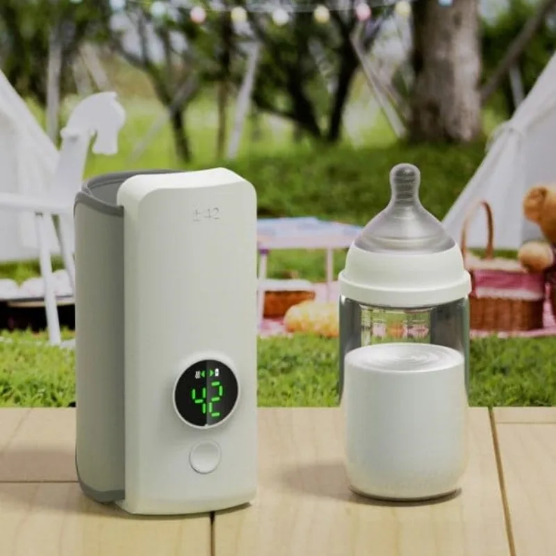 Portable bottle warmer outdoors next to a baby bottle